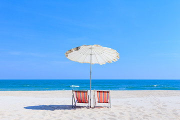 Colorful wooden beach chairs with sun umbrella