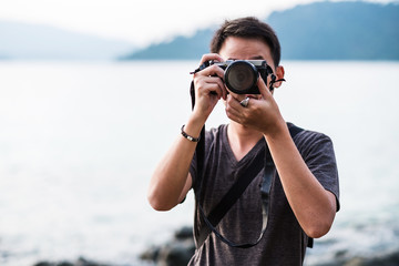 Asian guy holding camera taking a photograph