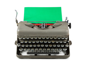 Vintage typewriter with green paper isolated on white background