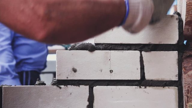 bricklayer lays white brick