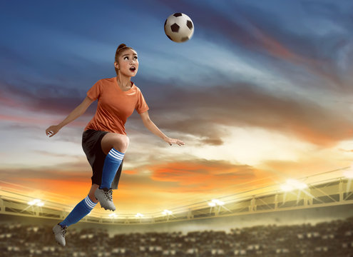 Female soccer player heading ball