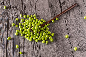 peas on a wood table with spoon