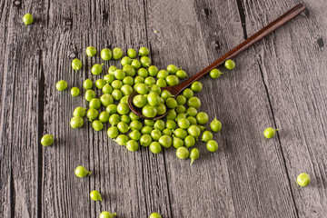 peas on a wood table with spoon