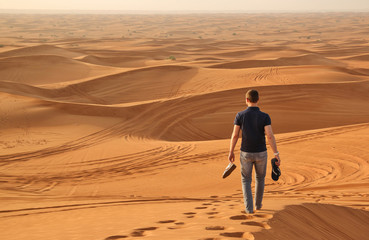 Fototapeta na wymiar Man walking alone in the sunny desert