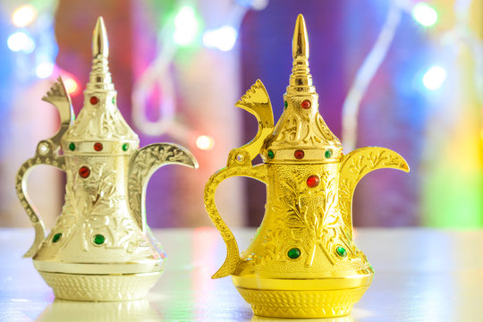 Dallah- Arabic Coffee pot in colorful illuminated out of focus light background.Ramadan, Eid background
