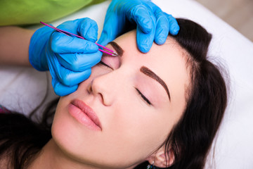 Obraz na płótnie Canvas woman getting tweezing eyebrow by beautician