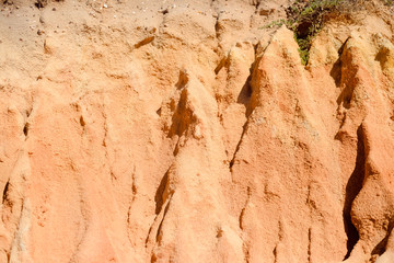 Closeup on red rock wall with sunny outdoors background