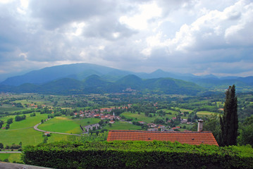 Naklejka premium On the foreground we can see various house roofs and in the background hills of Haute-Garonne countryside in the south of France. 