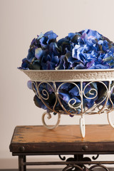 flowers of blue hydrangeas in a metal florid forged  vase