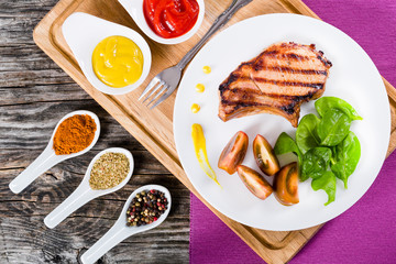 grilled pork chops on  white dish, top view
