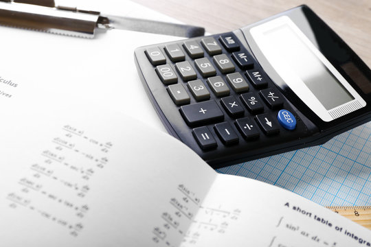 School supplies and textbook on mathematics close up