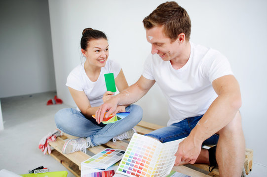 The young couple selects colors of a decor.