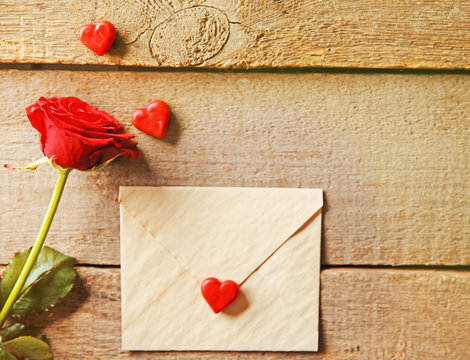 Beautiful rose with gift card on wooden background