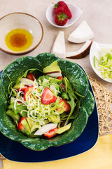 light salad with avocado, coconut, strawberry and rocket