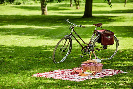 Bicycle and picnic spread in a lush green park