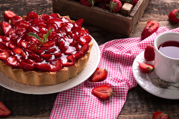 Tart with strawberries and whipped cream on wooden vintage table
