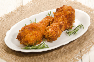 chicken drumstick with rosemary on oval plate