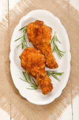 chicken drumstick with rosemary on oval plate