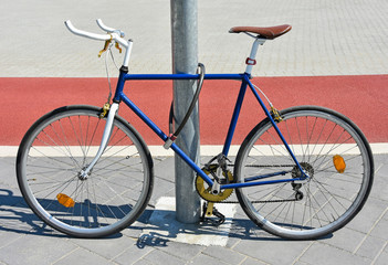 Fototapeta na wymiar Bicycle chained to a metal pole