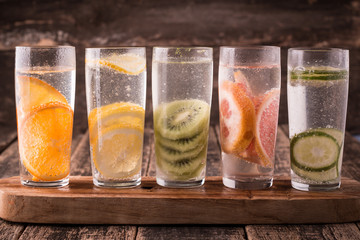Vitamin water with fruits, refreshment cold drink on wooden background