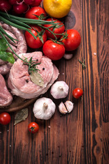 Fresh butcher cut meat assortment garnished with fresh rosemary on wooden table