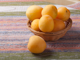 Fresh apricots in a basket on a tablecloth in rustic style. Sele