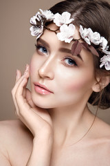 Beautiful woman portrait in tender colors. Young lady posing in studio with flowers on head. Pure skin, nice make up. - 112461473