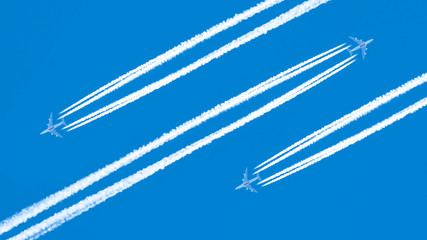 Three airplanes leaving traces on a clear blue sky