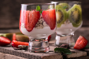 Healthy breakfast or morning snack with chia seeds granola, strawberries and kiwi, vegetarian food, diet and health concept