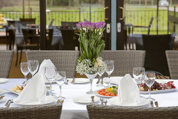 Beautifully decorated table in the restaurant. Fresh flowers and fruit.