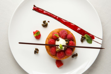 Sable breton or Breton shortbread with vanilla cream and raspberry coulis on white dish