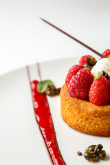 Sable breton or Breton shortbread with vanilla cream and raspberry coulis on white dish