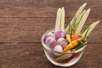 Spices , chilli , shallot , lemongrass in a glass cup on a woode