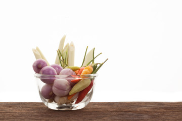 Spices , chilli , shallot , lemongrass in a glass cup on a woode