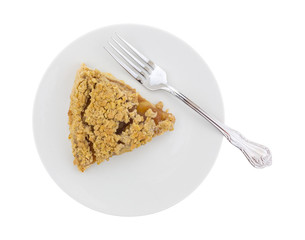 Top view of a slice of Dutch apple pie on a plate with a fork isolated on a white background.