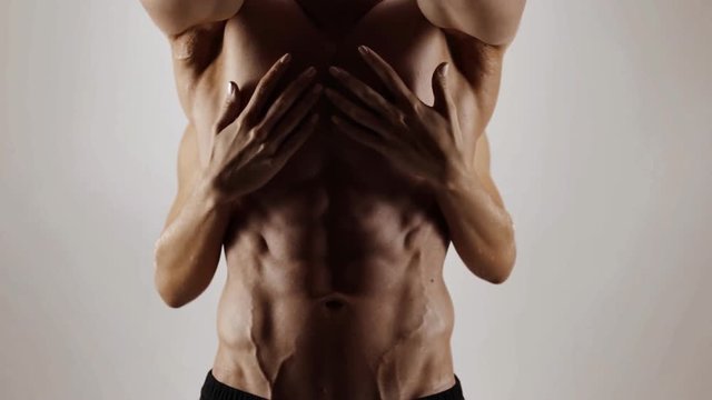 Hands of young woman touching athletic torso with abs of man. Graded