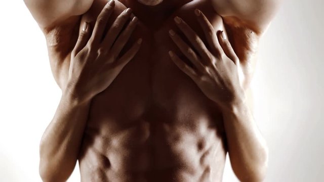 Hands of young woman touching athletic torso with abs of man. Graded