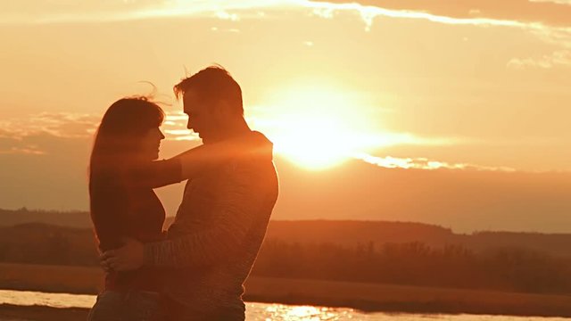 man and woman laughing and hugging at sunset slow motion video