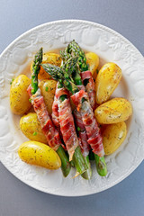 Bacon Wrapped Asparagus with young potato on plate