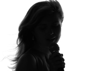 silhouette of a woman singing with a microphone in hands