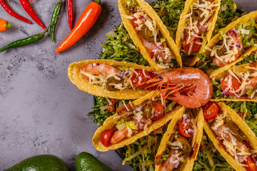 Tacos with shrimp, lettuce, cheese and jalapeno.