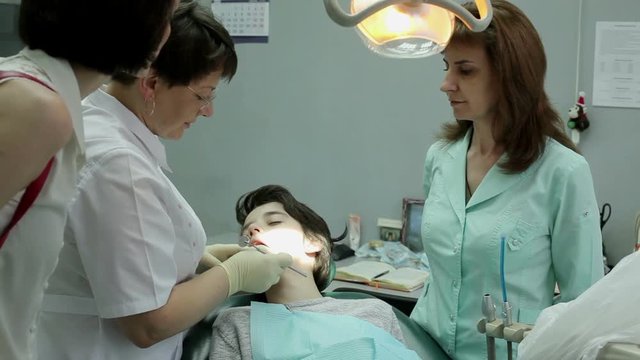 The boy and his mother at a visit at the dentist. Inspection of the bite of the guy.