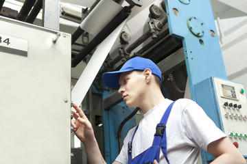 Man in cap working in newspaper factory