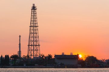 Fototapeta premium Oil refinery tower during sunrise, heavy industry background
