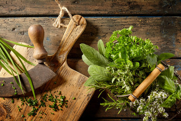 Various herbs in preparation on cutting board
