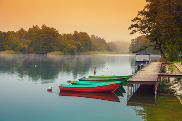 Autumn misty early morning. Wooden boats on the river bank