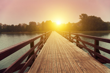 Wooden bridge over lake in early misty morning - Powered by Adobe