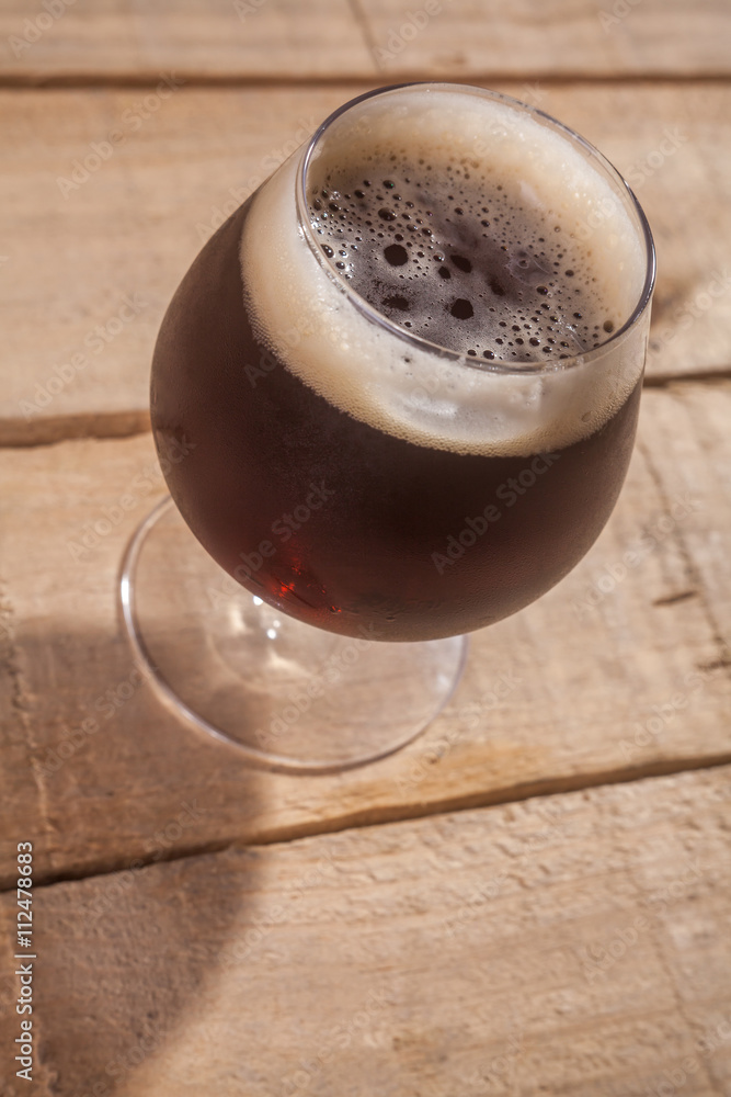 Wall mural Dark beer on wood