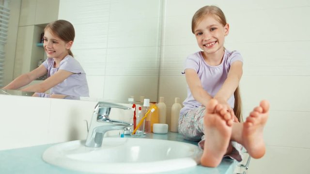 Portrait blonde child girl 7-8 years sitting in the bathroom