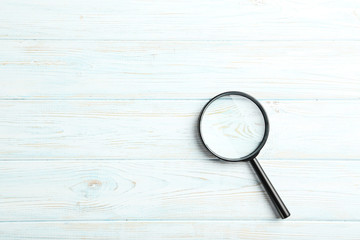 Magnifying glass on a blue wooden table